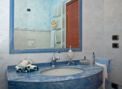 bagno azzurro con cornice per specchio